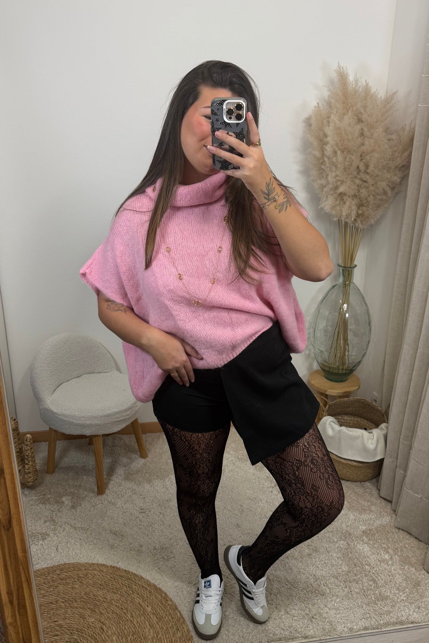 Look avec le pull sans manche avec col montant rose style oversize et la jupe short jessica et le collant résille