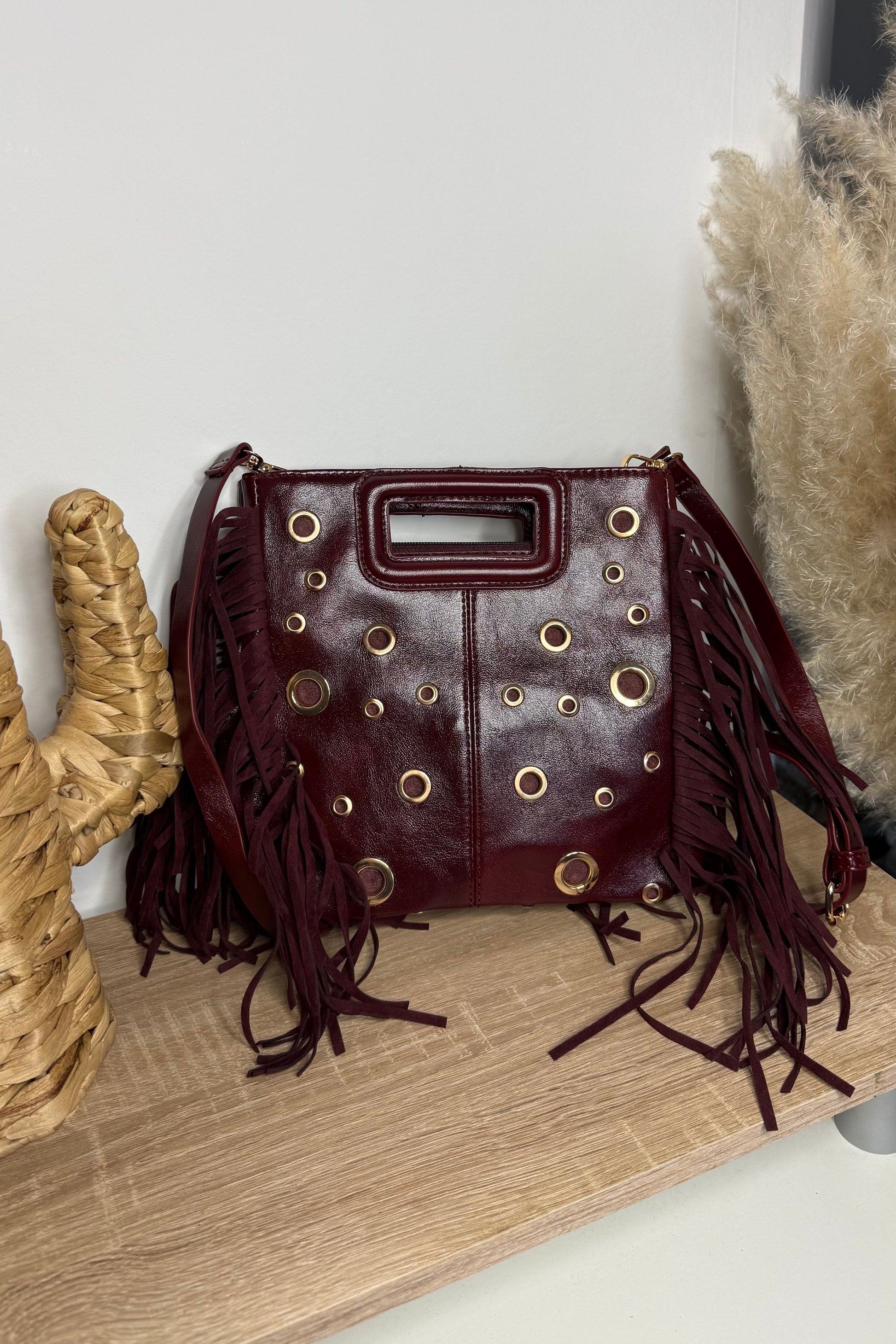 Sac Tendance avec la forme d'un sac de grande marque. details des oeillets et des franges sur le coté
