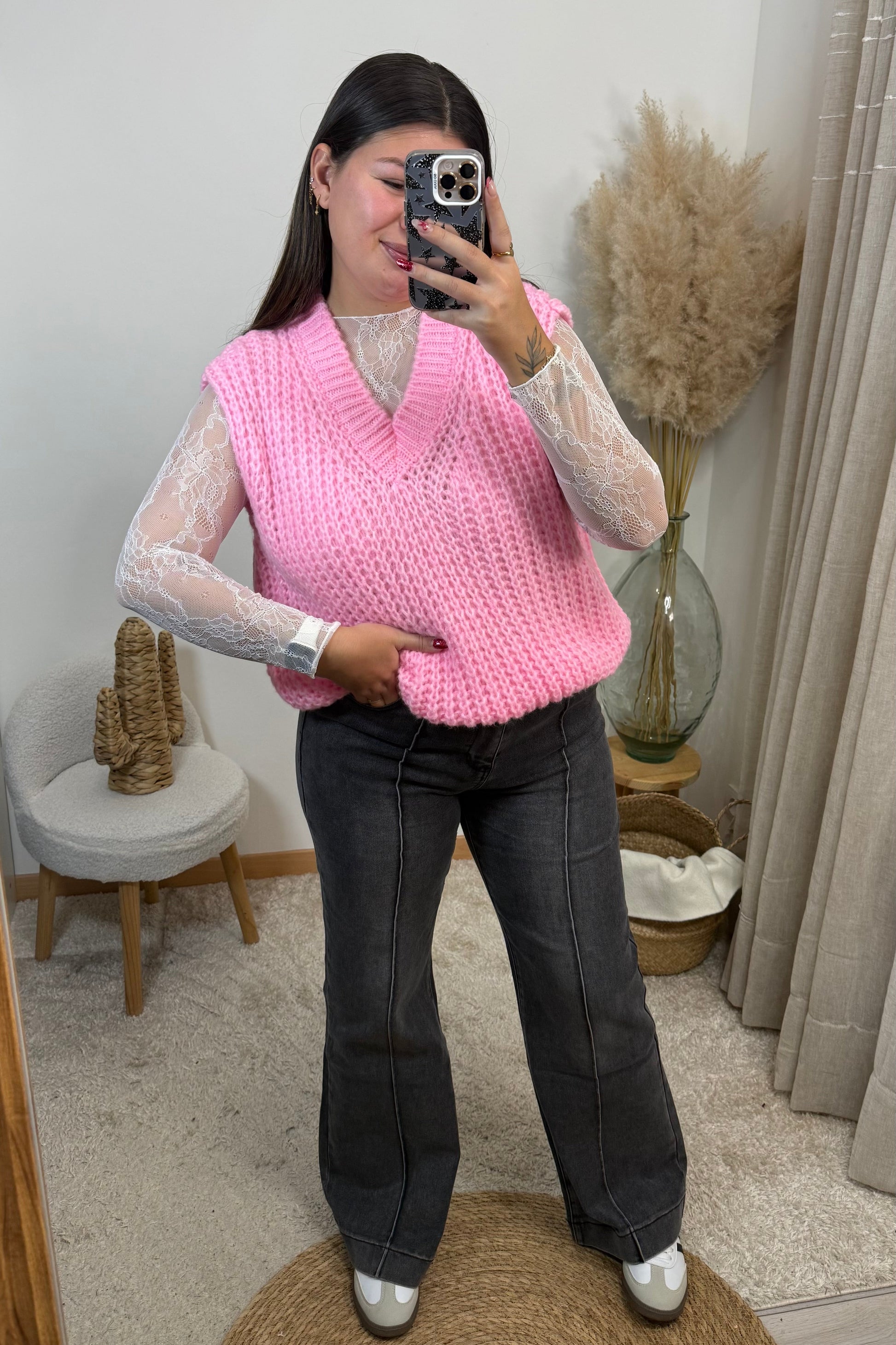 Look complet de la boutique avec le pull rosa sans manche en maille rose avec un décolleté v, le top Janelle en dentelle blanc, et un jean wide leg jambe droite gris foncé effet un peu délavé avec un liserai sur le devant avec des baskets esprit spezial / samba blanche basket clémence 