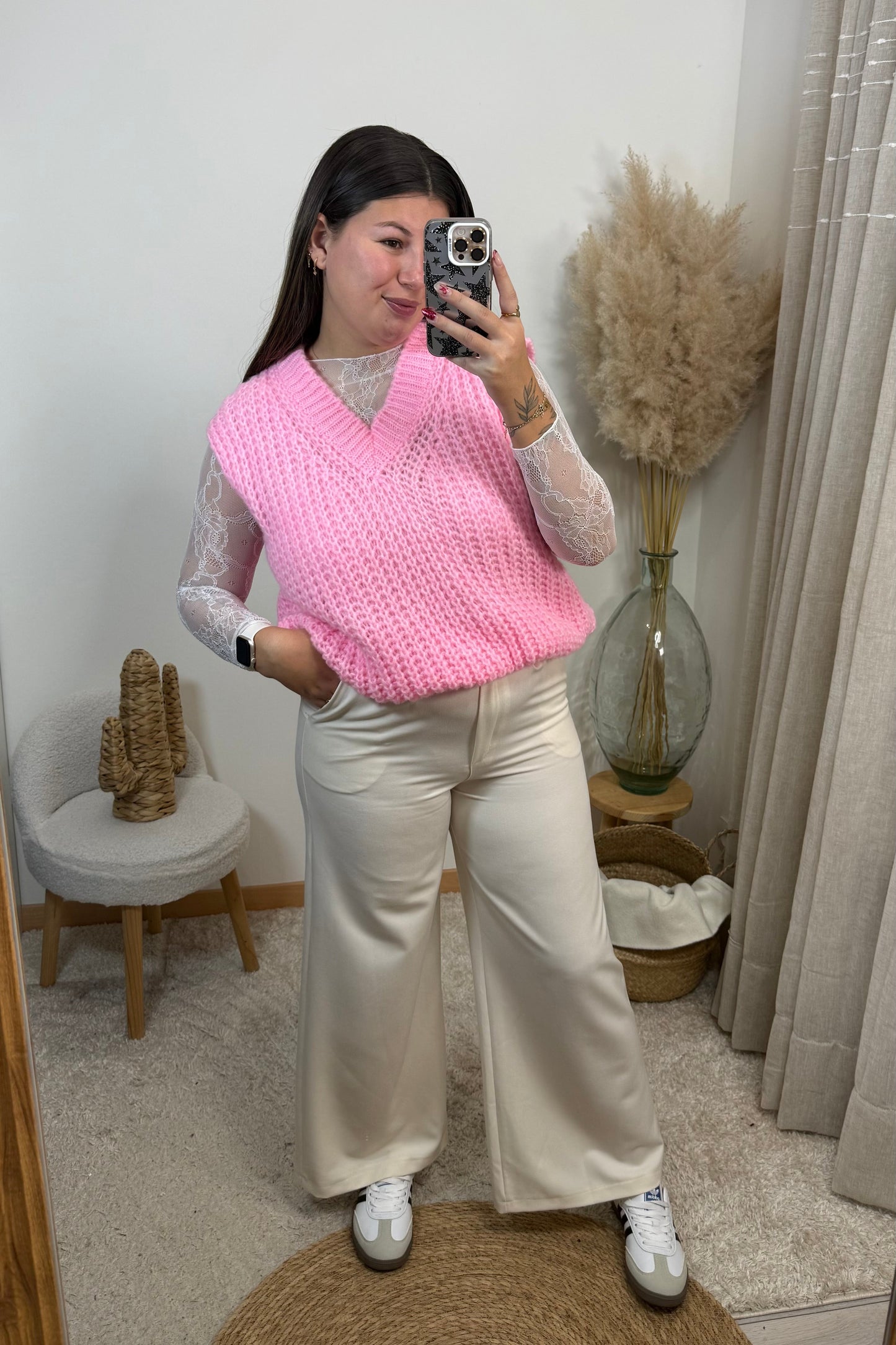 Look complet avec un pantalon style tailleur blanc Ecru du 36 au 42 avec un top en dentelle blanc et un pull sans manche rose en maille avec un décolleté v et une paire de basket samba spezial les baskets clémence