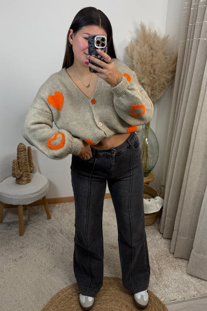 Look complet avec le gilet coralie cropé  gilet en maille beige avec des coeur orange et le jean Maël gris wide leg avec un liserai jean tres confortable du 36 au 44 avec les baskets clémence type spezial samba 