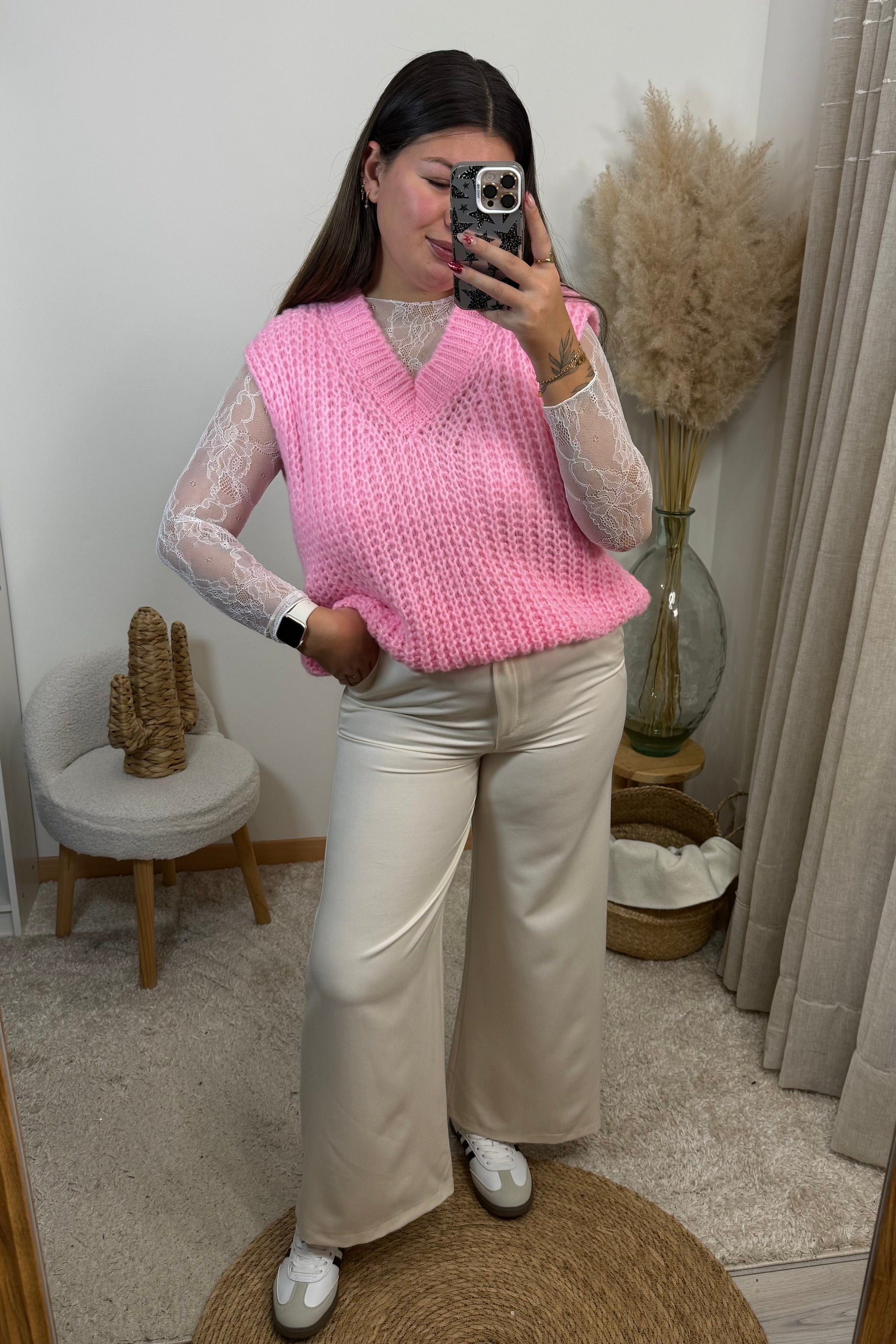 Look complet avec un pantalon style tailleur blanc Ecru du 36 au 42 avec un top en dentelle blanc et un pull sans manche rose en maille avec un décolleté v et une paire de basket samba spezial les baskets clémence