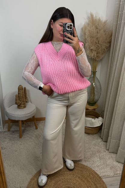 Look complet avec un pantalon style tailleur blanc Ecru du 36 au 42 avec un top en dentelle blanc et un pull sans manche rose en maille avec un décolleté v et une paire de basket samba spezial les baskets clémence