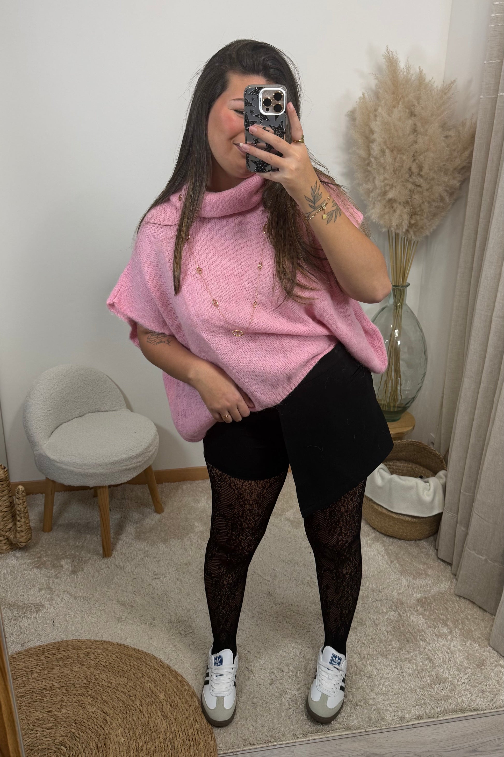 Look avec le pull sans manche avec col montant rose style oversize et la jupe short jessica et le collant résille 